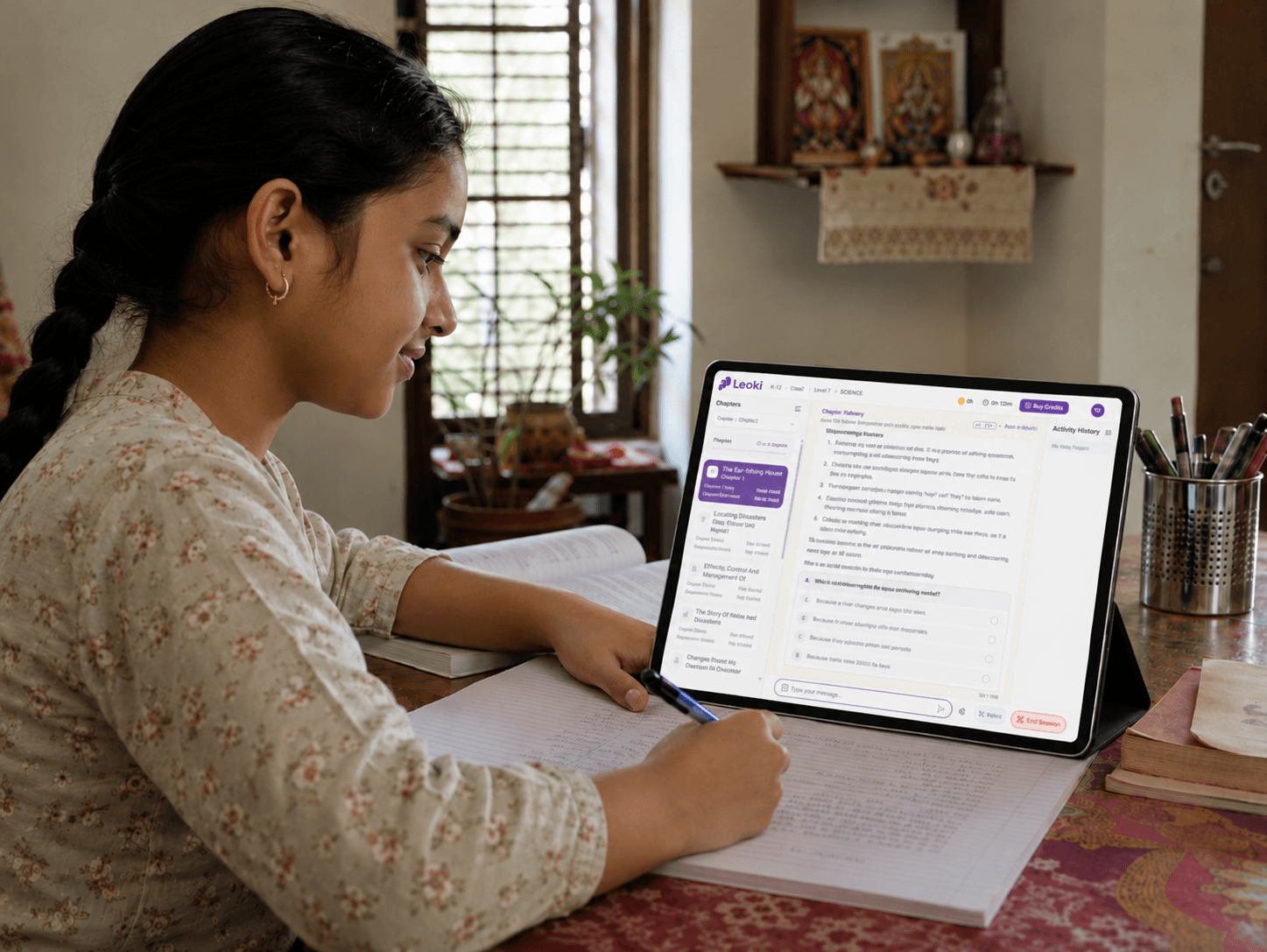 A student studying a science chapter on Leoki on a tablet at home, writing notes